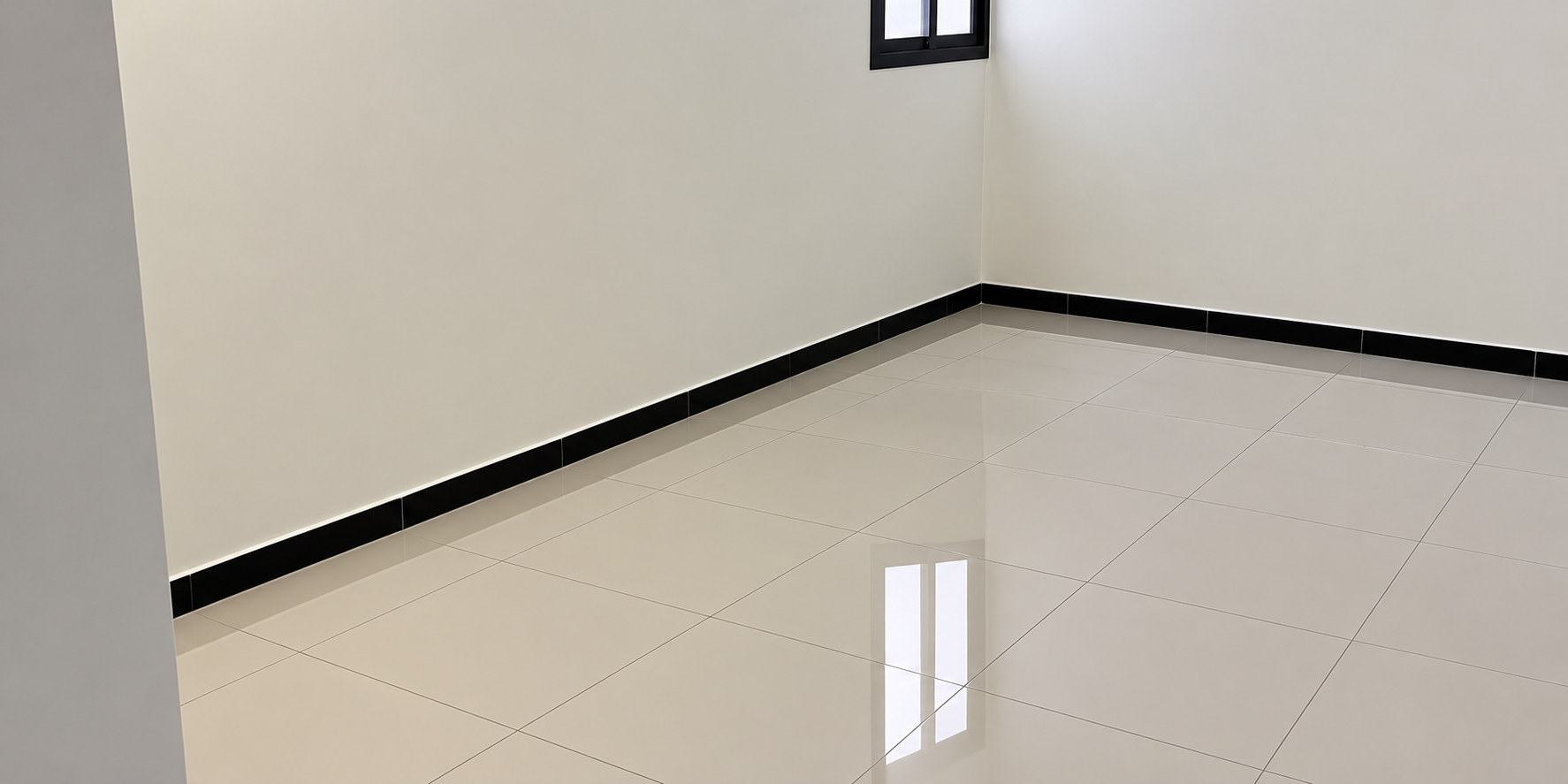 Assentamento de porcelanato polido de grande formato com acabamento espelhado, rodapé de contraste e reflexo natural da janela